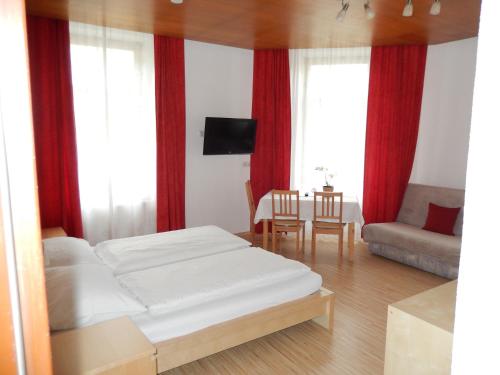 林茨Hotel "Wilder Mann"的一间卧室配有床,客厅配有红色窗帘