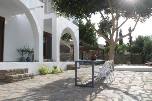 PírgosA Crystal Clear House in Pyrgos, Heraklion Crete的一个带桌椅和树的庭院