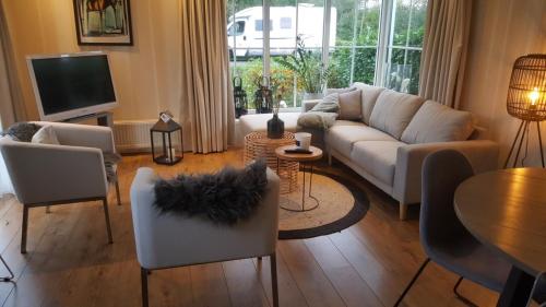 羊角村Resort Venetie Chalet nr.42的客厅配有沙发、椅子和桌子