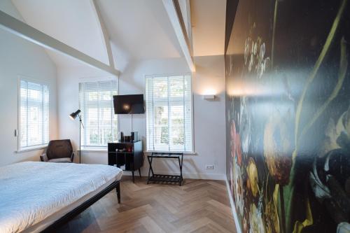 布勒克伦Boutique B&B Oud Aa的卧室配有一张床,墙上挂有绘画作品