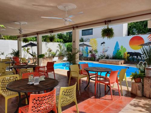 梅里达Jardín Mérida的游泳池前设有桌椅的餐厅