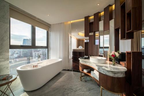 河内Soleil Boutique Hotel Hanoi的带浴缸的浴室和大窗户