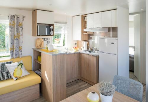 维尔通Mobil-Home XXL 4 chambres - Camping La Colline的一间位于客房内的带黄色沙发的小厨房