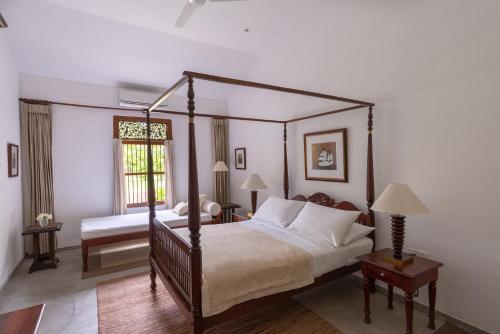本托塔Nyne Hotels - Rock Villa, Bentota的一间卧室设有四柱床和窗户。