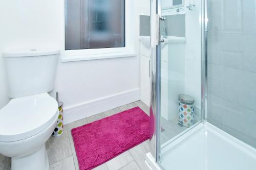 Trent ValeTownhouse @ 543 London Road Stoke的浴室设有卫生间和带粉红色地毯的淋浴。