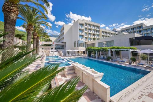 布德瓦地中海酒店及度假村的一座楼前棕榈树游泳池