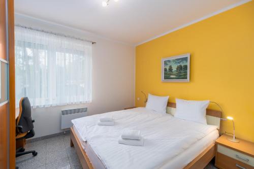 米兹多洛杰Morskie Oko D12 by Renters的一间卧室设有一张黄色墙壁的大床