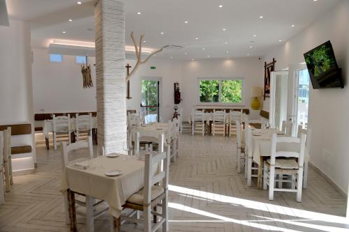 蓬扎Piccolo Hotel Luisa的用餐室配有白色的桌子和白色的椅子