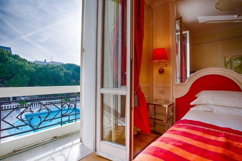里乔内德班斯大酒店的一间卧室设有1张床和1扇窗户的阳台