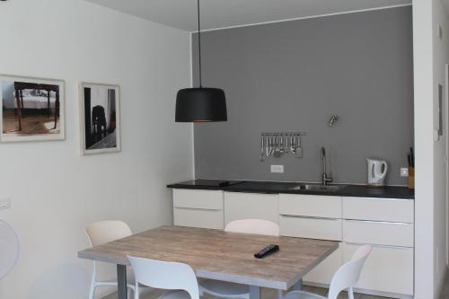 博尔扎诺Apartments Rathaus 008 - Municipio 008的厨房配有木桌和白色椅子