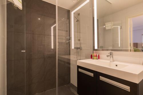 布鲁塞尔佛罗伦萨瑞贞德斯酒店的一间带水槽和玻璃淋浴的浴室