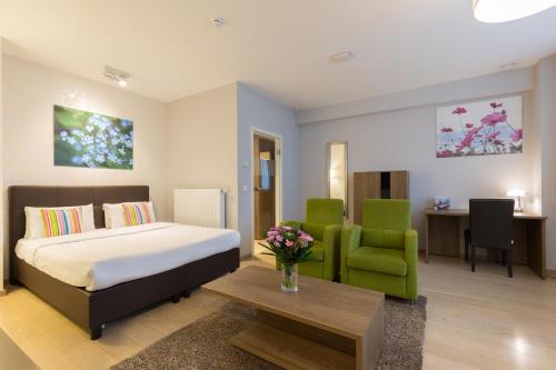 布鲁塞尔佛罗伦萨瑞贞德斯酒店的一间卧室配有一张床和一把绿色椅子