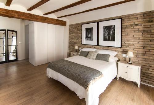 RoquetasLa Casa del Canal的一间卧室设有一张大床和砖墙