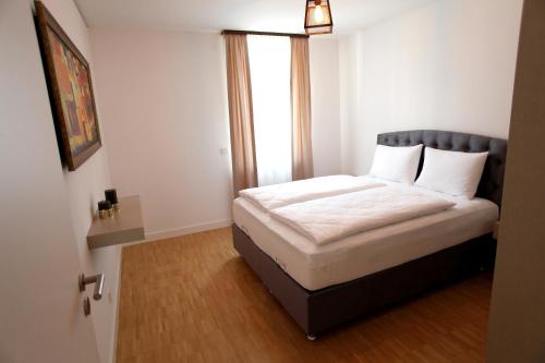 海德堡Boardinghotel Westarkaden Suites的一个小房间的一个床位,设有窗户