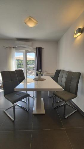 斯托莫斯卡Apartments with sea view的一间带桌子和两把椅子的用餐室