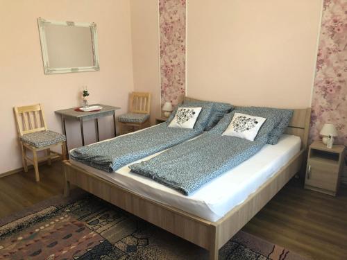 MezőpeterdEmese vendégház的一间卧室配有一张床、两把椅子和镜子