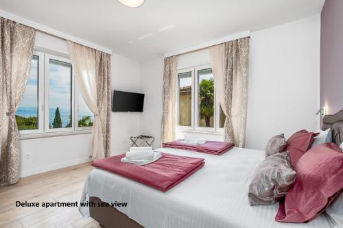 奥帕提亚Apartments Liana的一间卧室设有两张床和两个窗户。