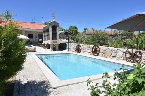 阿吉亚尔小镇Quinchoso dos Bentos的一座带石墙的庭院内的游泳池