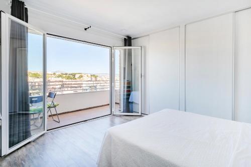 阿利坎特Beach Suite, city & mountain view的一间带白色床的卧室和一个阳台
