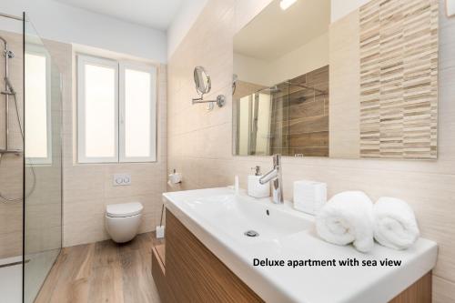 奥帕提亚Apartments Liana的一间带水槽、卫生间和镜子的浴室