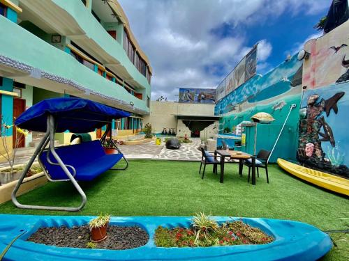 巴克里索莫雷诺港Galápagos Eco Friendly的庭院配有椅子、遮阳伞和桌子。