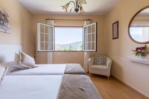 塞尔塞迪利亚El Balcón de Siete Picos的卧室配有床、椅子和窗户。