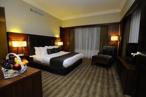 峇株巴辖卡捷琳娜酒店的配有一张床和一把椅子的酒店客房