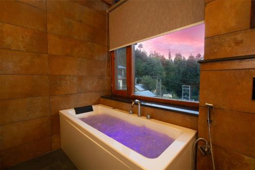 马拉里Aloka Resort的带浴缸和窗户的浴室