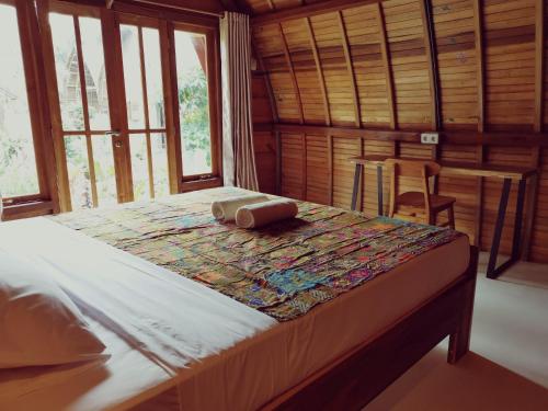 巴图卡拉Coconut Tree Cottages的配有窗户的客房内的一张大床