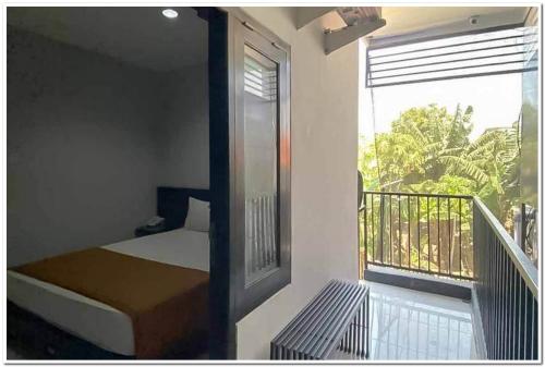 GabungLosmen Family Syariah Bypass Juanda Mitra RedDoorz的一间卧室配有一张床,阳台设有窗户