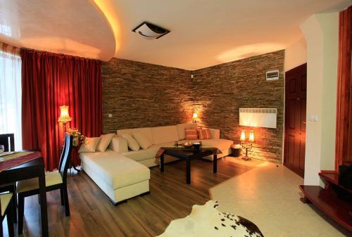 潘波洛沃Ski Villa in Pamporovo Forest的客厅配有白色沙发和砖墙
