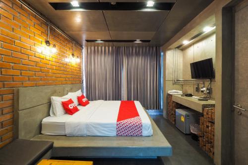 Ban KoOYO 75368 Demadre Resort的一间卧室设有一张床和砖墙