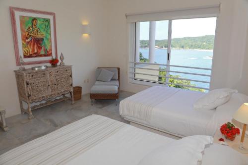 Santa María Huatulco1031 - Villas Carey Condo的一间卧室设有两张床和一个美景窗户。