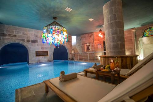 格雷梅Imperial Cave Suites & Spa的一个带吊灯的大型室内游泳池