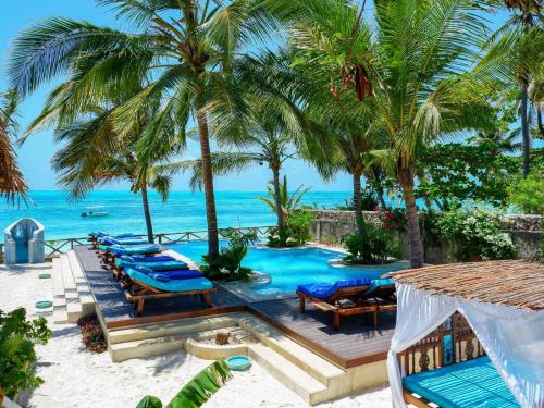 江比阿Casa Paradis的海滩上带椅子和棕榈树的游泳池