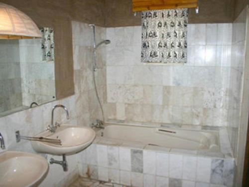 SesfonteinFort Sesfontein Lodge & Safaris的带浴缸、水槽和浴缸的浴室