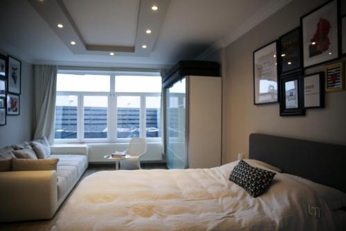 韦尔维耶Maison avec Jacuzzi 5ch的一间卧室配有一张床、一张沙发和一个窗口