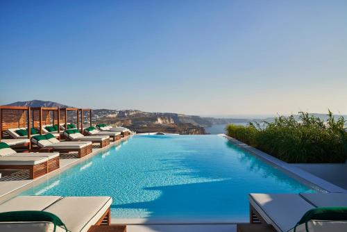费拉Katikies Garden Santorini - The Leading Hotels Of The World的一个带椅子的游泳池,享有水景