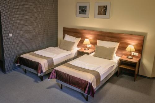 奥普尔Zajazd u Dziadka的酒店客房设有两张床和两盏灯。
