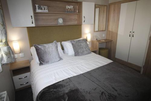 博特夫加滕The One - Chalet in the Cairngorms的一间卧室配有一张大床和两个枕头