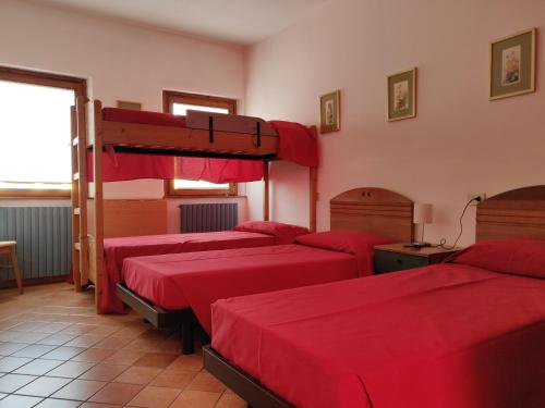 圣维托阿尔塔利亚门托奥斯特罗欧罗巴旅舍的一间设有四张红色床单的房间