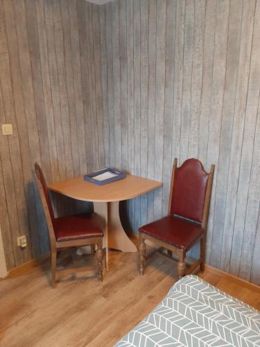 沙勒罗瓦ESCALE DU BOURLINGUEUR的一张桌子和两把椅子,上面有一本书