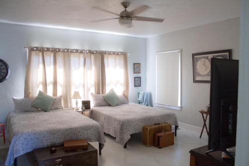 迈阿密Spacious and Comfy Suite near MIA - 6G的一间卧室设有两张床、一台电视和一扇窗户。