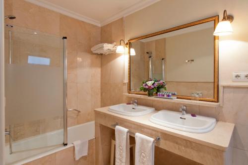 塞维利亚玛利亚多娜酒店的浴室设有2个盥洗盆、淋浴和镜子。