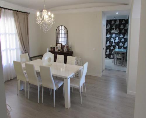 马拉加Apartamento a 50 metros de la playa malagueta con vistas al mar的一间配备有白色桌椅的用餐室
