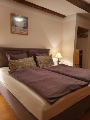 韦尼格罗德Café Burgstraße的一间卧室配有一张大床,提供紫色床单和枕头