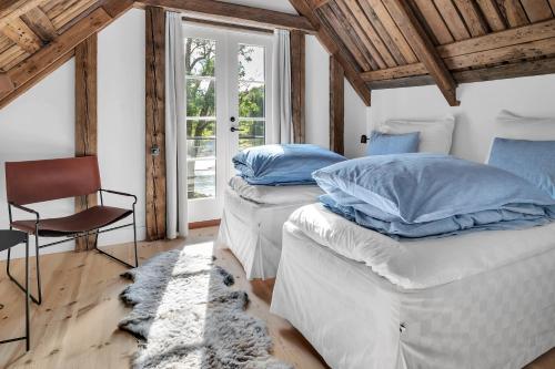 克里斯蒂安桑Boen Gård的配有椅子和窗户的客房内的两张床