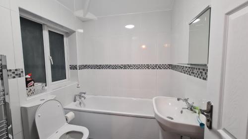 德比Spacious 3 Bedroom House, 6 beds in Spondon, Derby with Parking的白色的浴室设有卫生间和水槽。