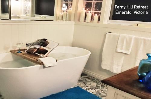 翡翠城Ferny Hill Retreat, Emerald Victoria的带浴缸的浴室,内有杂志