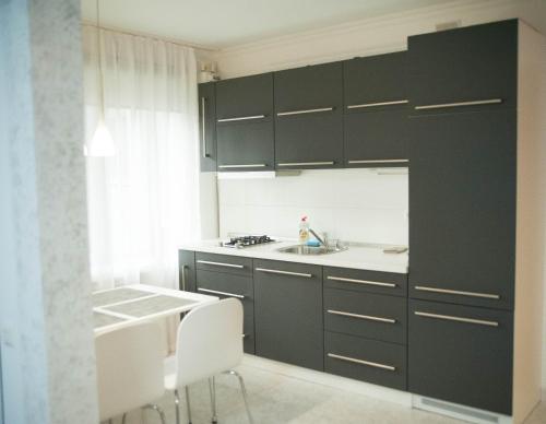 基辅Apartment FeLi House的厨房配有黑色橱柜、水槽和桌子